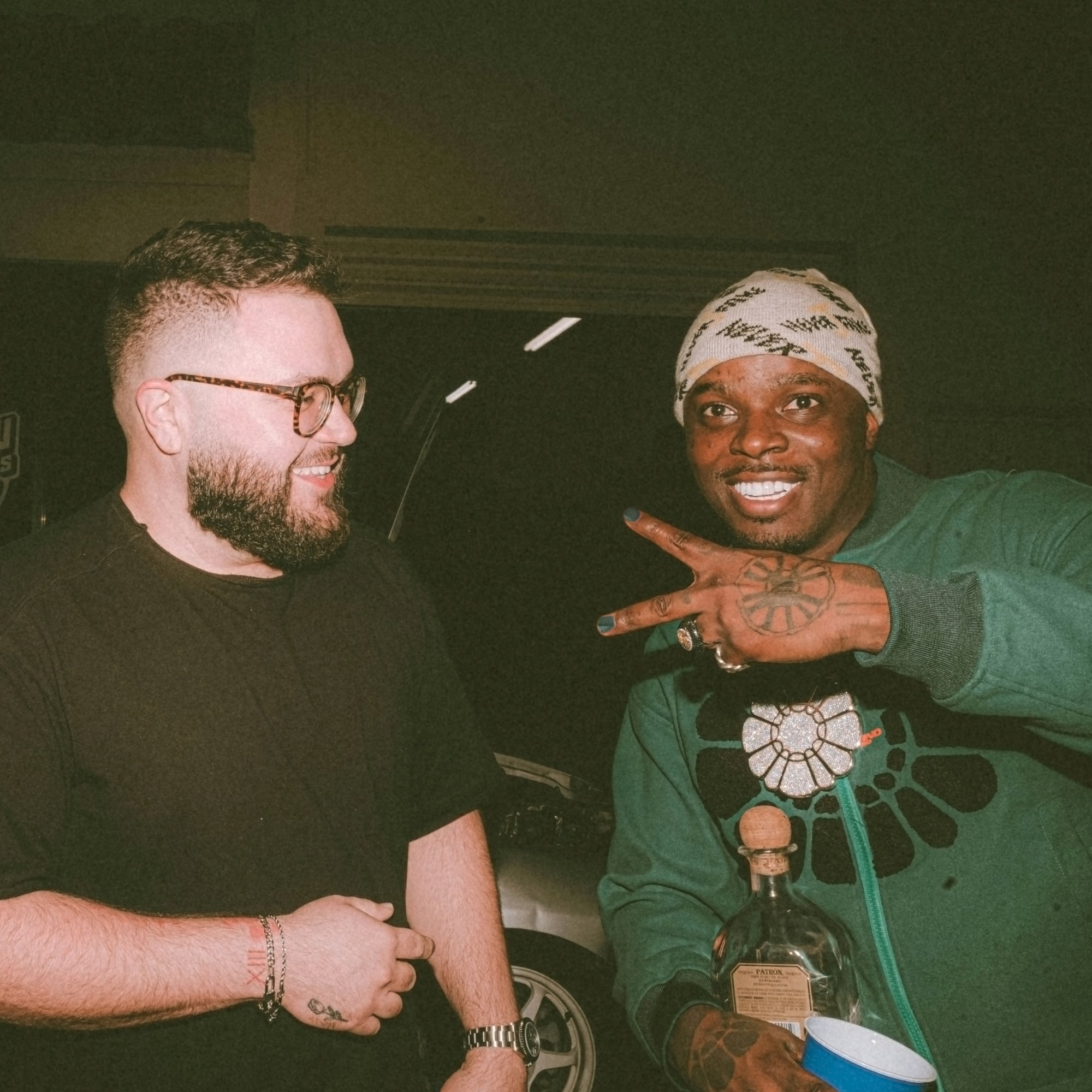 Man posing with his friend at a party while wearing Maverick X nail polish.