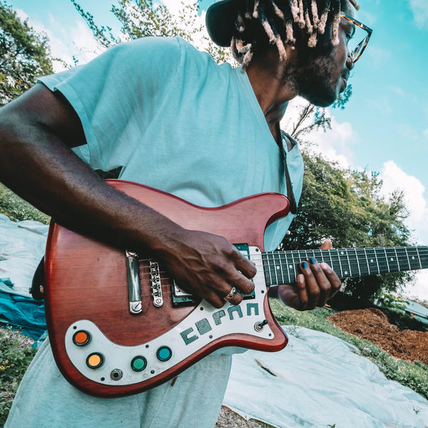 Man playing guitar and wearing Renegade Y nail polish.