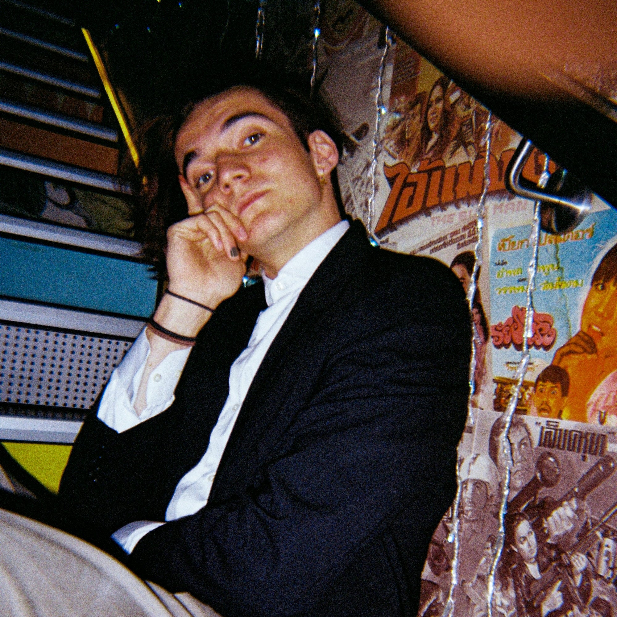 Man sitting on stairs inside a bar wearing Rooted X nail polish.